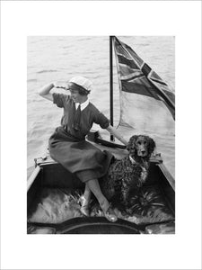 Gladys Wilburn, a motor boat driver with the Women's Royal Naval Service, in her boat, the 'BALMACAAN', with her spaniel dog, Southwick, Sussex, 1918.