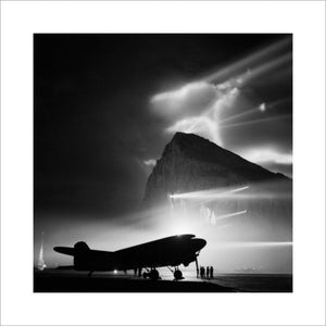 A Douglas Dakota of BOAC at Gibraltar, silhouetted by searchlights on the Rock.