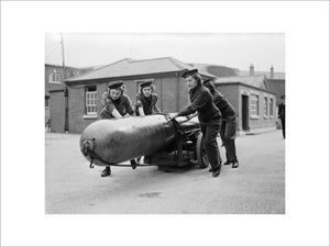 Members of the Women's Royal Naval Service (WRNS) move a torpedo for loading into a submarine at Portsmouth, 29 September 1943.