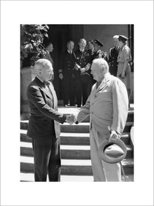 President Harry Truman and Winston Churchill shake hands on the steps of Truman's residence during the Potsdam conference, 16 July 1945.
