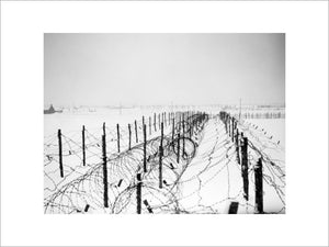 Lines of barbed-wire obstacles stretch across snow-covered fields near Menin in France, 21 January 1940.