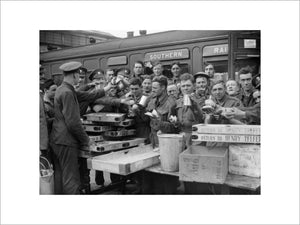 Troops evacuated from Dunkirk enjoying tea and other refreshments at Addison Road station in London, 31 May 1940.