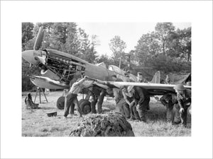 Men of an RAF Repair and Salvage Unit working on a damaged Supermarine Spitfire Mk IX of No 403 Squadron, Royal Canadian Air Force, at a forward airstrip in Normandy, 19 June 1944.