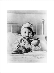 Eileen Dunne, aged three, sits in bed with her doll at Great Ormond Street Hospital for Sick Children, after being injured during an air raid on London in September 1940.
