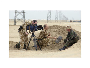 Sergeant Stuart McKenzie and Captain Guy Gatenby of the Army Mobile News Team, film an interview with a REME soldier attached to 6 Supply Regiment Royal Logistics Corps, at Camp Fox in the Kuwaiti desert, 11 Febraury 2003.