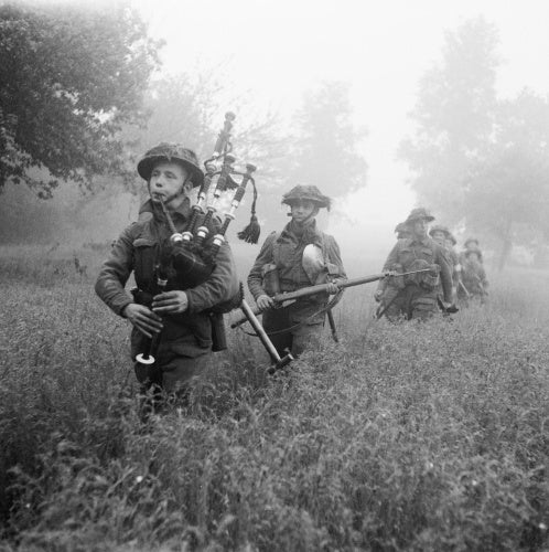 Led by their piper, men of 7th Seaforth Highlanders, 15th (Scottish) Division advance during Operation 'Epsom' in Normandy, 26 June 1944.