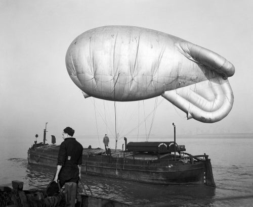 A kite balloon tethered to the balloon barge NORMAN WADE on the River Humber, at No. 17 Balloon Centre at Sutton-on-Hull in Yorkshire, January 1943.