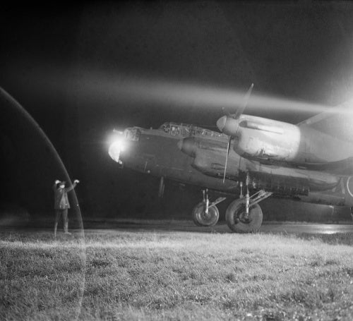 An Avro Lancaster Mk III of No. 49 Squadron RAF is guided to its dispersal point at Fiskerton, Lincolnshire, after returning from a raid on Berlin, 22 November 1943.