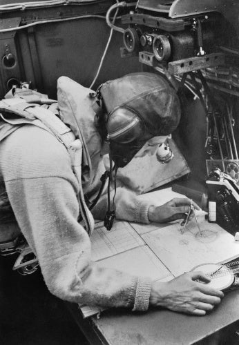 A Cecil Beaton photograph of the navigator working at his chart table in an RAF Stirling bomber, 1941.