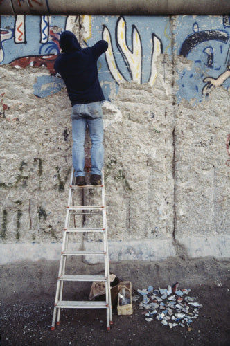 A Berliner chipping away part of the newly-opened Berlin Wall, 23 January 1990