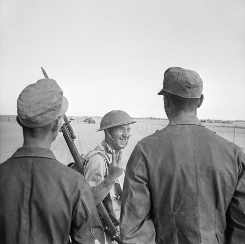 A British soldier gives a V-for-Victory sign to German prisoners captured at El Alamein, 26 October 1942.