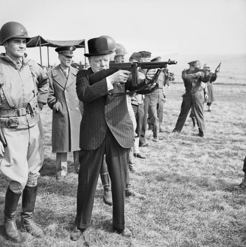 Winston Churchill fires a Thompson submachine gun alongside the Allied Supreme Commander, General Dwight D Eisenhower, during an inspection of US invasion forces, March 1944.