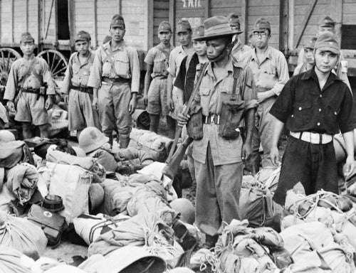 A Gurkha soldier guards Japanese prisoners on their way to POW camps outside Bangkok, September 1945.
