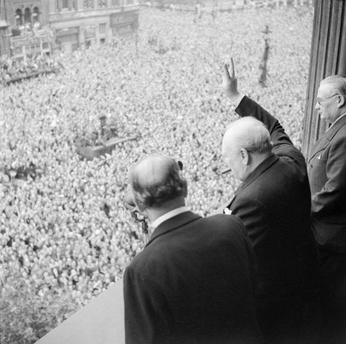 Winston Churchill waves to crowds in Whitehall in London as they celebrate VE Day, 8 May 1945.