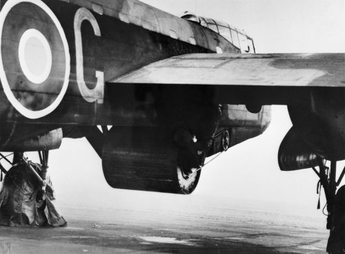 A practice 'Upkeep' weapon attached to the bomb bay of Wing Commander Guy Gibson's Avro Lancaster of No. 617 Squadron at Manston, while conducting dropping trials for the Dams Raid off Reculver, May 1943.