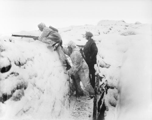 Two men of the 12th East Yorkshires wearing snow suits leaving their snow-covered trench on daylight patrol. Arleux Sector, 9 January 1918.