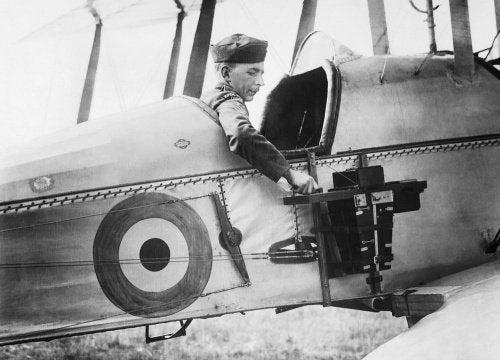 A sergeant of the Royal Flying Corps demonstrates a C type aerial reconnaissance camera fixed to the fuselage of a BE2c aircraft, 1916.