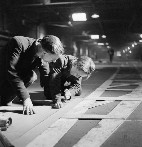 Two men cutting templates in the mould loft.