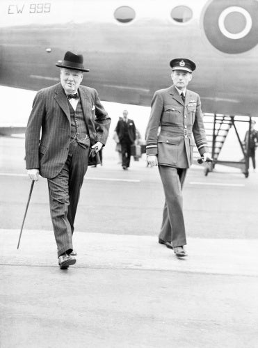 Winston Churchill, accompanied by Air Marshal the Hon. Sir Ralph Cochrane, Air Officer Commanding in Chief, Transport Command, walks from his Douglas Skymaster Mark I, EW999, at Northolt, Middlesex.