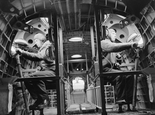 Two gunners in Short Sunderland Mark I, N9027, of No 210 Squadron RAF based at Oban, Argyll, sit at their positions with .303 Vickers K-type machine guns, mounted in the upper fuselage hatches.