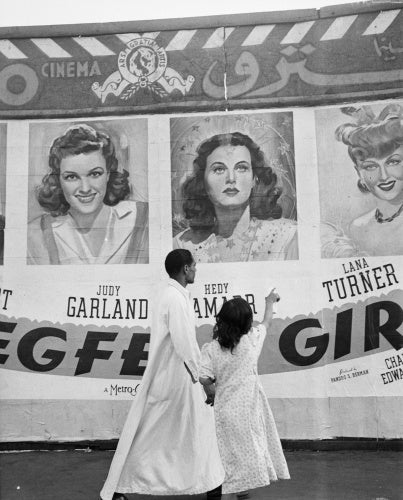 A Hollywood film poster attracts the attention of local Egyptians, Cairo, Egypt, 1942