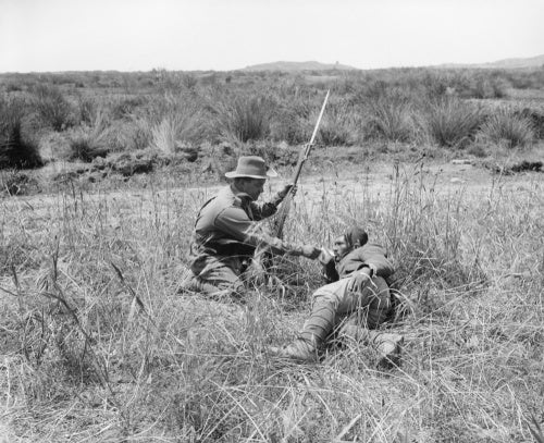 An Australian infantryman gives a drink to a wounded Turkish soldier during the Gallipoli Campaign in 1915.