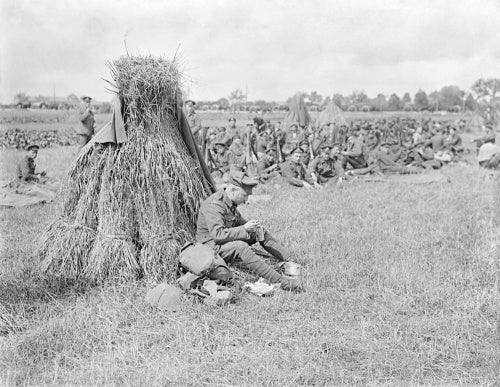 A Sergeant Major of the 16th Irish Division having a breakfast meal by a wheatsheaf. The Amiens - Albert Road, 25th August 1916.