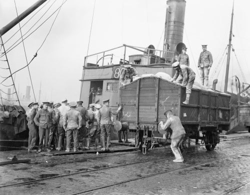 British troops unloading flour from ships and loading into railway trucks. Calais, March 1917.