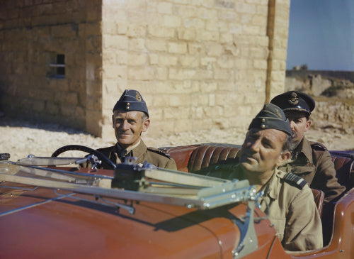 A red MG sports car with Air Vice Marshal Keith Park,  at the wheel and Air Vice Marshal Arthur Coningham
