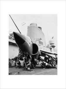 Armourers 'bombing up' a Sea Harrier on board HMS INVINCIBLE during the Falklands War, 1982.