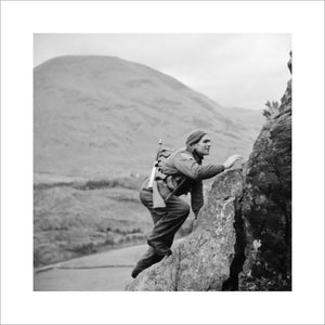A soldier from No. 1 Commando climbs up a steep rock face during training at Glencoe in Scotland, 19 November 1941.