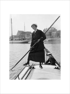 Gladys Wilburn of the Womens Royal Naval Service (WRNS) using a boat-hook to push her motor boat, the BALMACAAN, away from the shore at Southwick harbour, 1918.