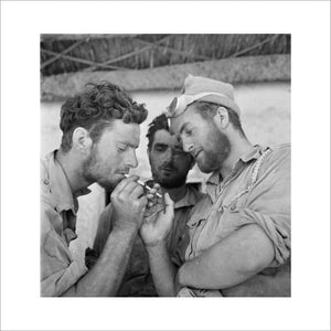 Men of the Long Range Desert Group relax with cigarettes after returning to headquarters at the end of a desert patrol, Siwa, Libya, 1942