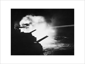 HMS MAURITIUS firing during a night action against enemy ships off the French coast between Brest and Lorient, 23 August 1944.