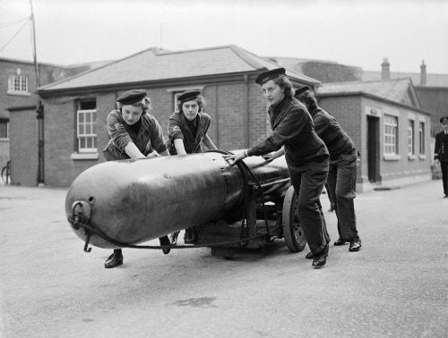 Members of the Women's Royal Naval Service (WRNS) move a torpedo for loading into a submarine at Portsmouth, 29 September 1943.