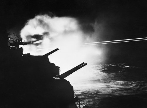 HMS MAURITIUS firing during a night action against enemy ships off the French coast between Brest and Lorient, 23 August 1944.