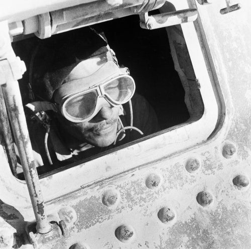 Cecil Beaton portrait of a British tank driver peering out of his Grant tank in North Africa, 1942.