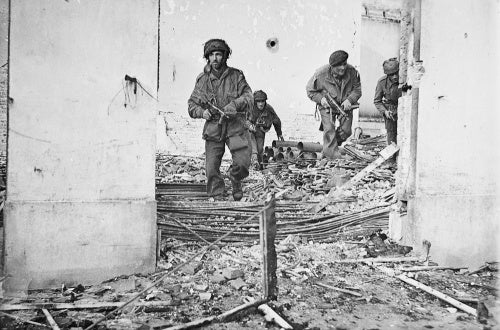 British airborne troops moving through a shell-damaged house in Oosterbeek near Arnhem during Operation 'Market Garden', 23 September 1944.