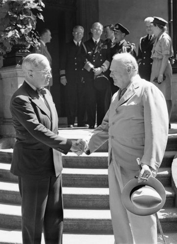 President Harry Truman and Winston Churchill shake hands on the steps of Truman's residence during the Potsdam conference, 16 July 1945.