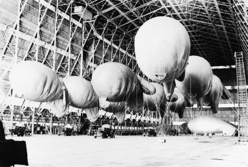 Kite balloons of No. 1 Balloon Training Unit await their handlers, during the morning parade in No. 1 Airship Shed at Cardington, October 1940.