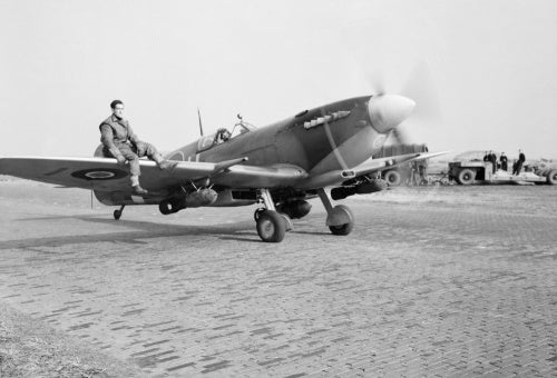 A Supermarine Spitfire Mk IXE of No. 412 Squadron RCAF, armed with a 250-lb GP bomb under each wing, taxies out for a sortie at Volkel, Holland, 27 October 1944.