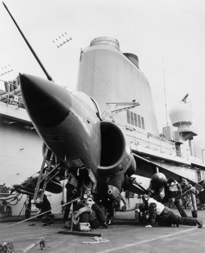 Armourers 'bombing up' a Sea Harrier on board HMS INVINCIBLE during the Falklands War, 1982.