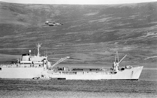 An Argentine Dagger aircraft makes a low-level attack on RFA SIR BEDIVERE in San Carlos Water in the Falkland Islands, 24 May 1982.