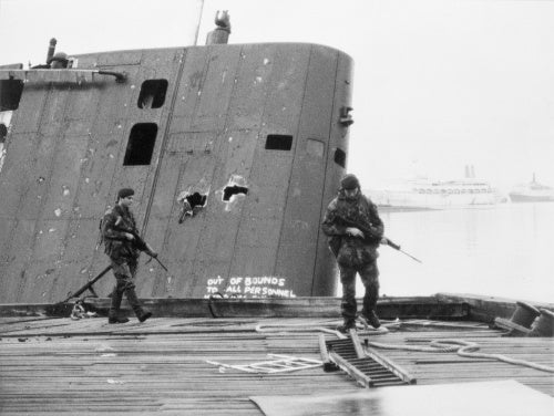 Royal Marines patrol past the abandoned Argentine submarine SANTA FE on South Georgia, 28 May 1982.