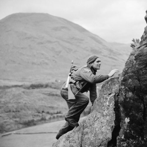 A soldier from No. 1 Commando climbs up a steep rock face during training at Glencoe in Scotland, 19 November 1941.