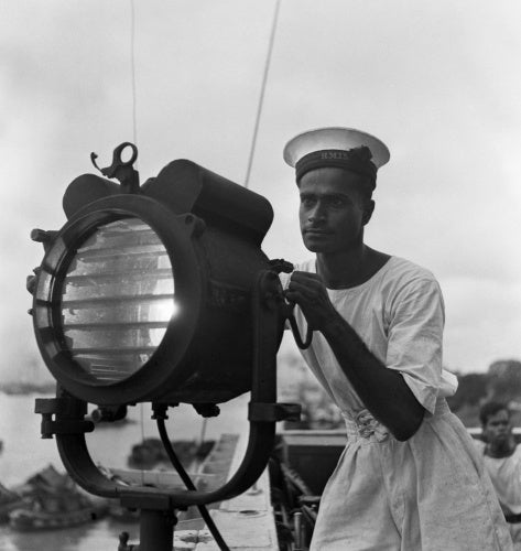 Cecil Beaton portrait of an Indian naval rating operating a signal lamp on the sloop SUTLEJ at the Royal Indian Naval Station at Calcutta, 1944.