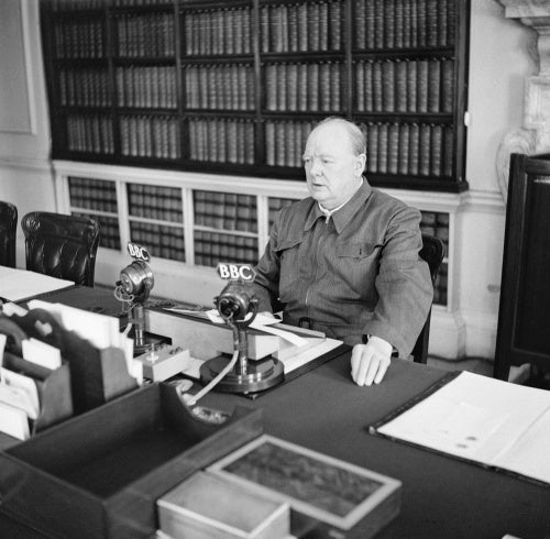 Winston Churchill makes a radio address from his desk at 10 Downing Street, wearing his 'siren suit', June 1942.