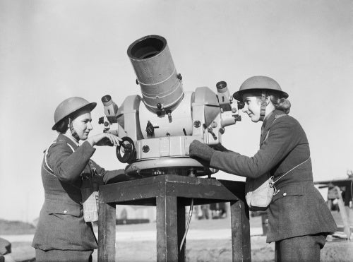 Two members of the Auxiliary Territorial Service (ATS) check the accuracy of anti-aircraft fire from a gun battery during the Second World War.
