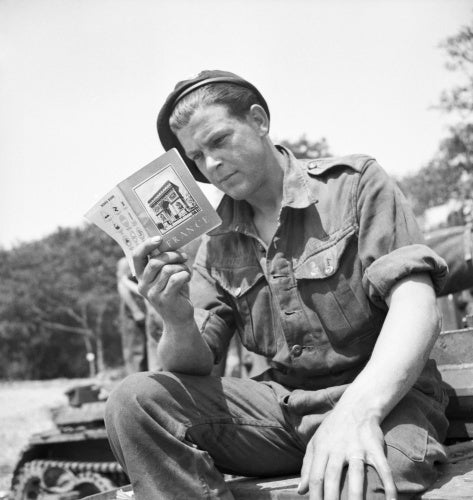 A soldier from 101st Light Anti-Aircraft Regiment prepares for D-Day by reading his French handbook at a camp near Portsmouth, 29 May 1944.