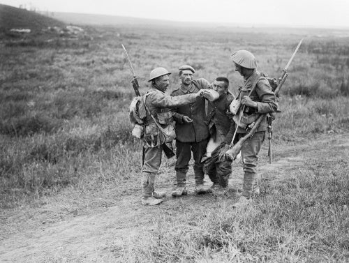 British infantrymen give a helping hand to wounded German prisoners near La Boisselle during the Battle of the Somme, 3 July 1916.